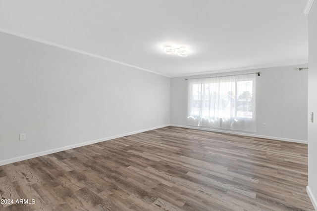 empty room with crown molding and hardwood / wood-style floors