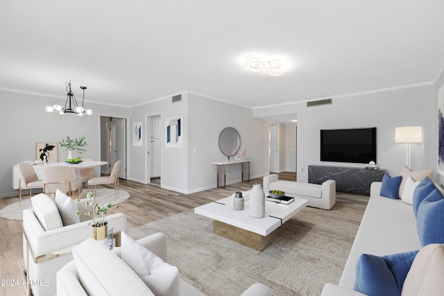 living room with ornamental molding, light wood-type flooring, and an inviting chandelier