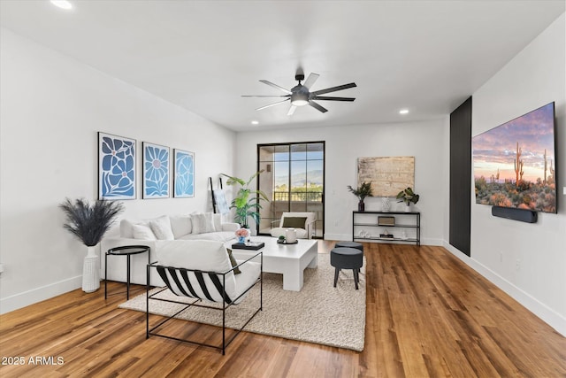 living room featuring ceiling fan and hardwood / wood-style floors