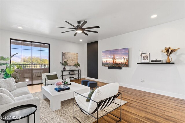 living room featuring light hardwood / wood-style floors and ceiling fan