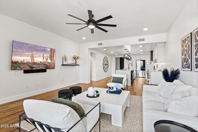 living room featuring hardwood / wood-style flooring and ceiling fan