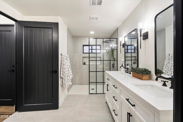 bathroom with tile patterned floors, vanity, and tiled shower