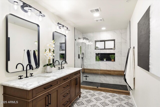 bathroom featuring a tile shower and vanity