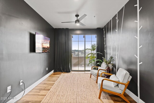 living area with hardwood / wood-style floors and ceiling fan