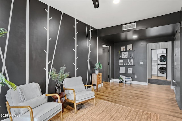 interior space featuring stacked washer / dryer and wood-type flooring