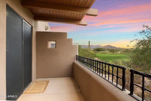 balcony at dusk featuring a mountain view