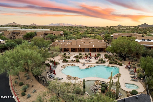 pool at dusk featuring a mountain view