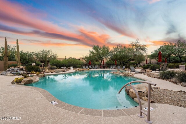 pool at dusk with a patio