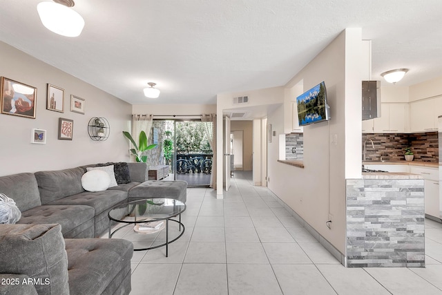 living area featuring light tile patterned flooring and visible vents