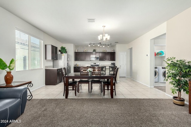 carpeted dining area with washing machine and dryer and an inviting chandelier