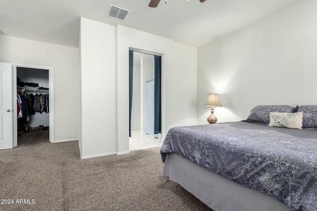 bedroom featuring ceiling fan, a spacious closet, light carpet, and a closet