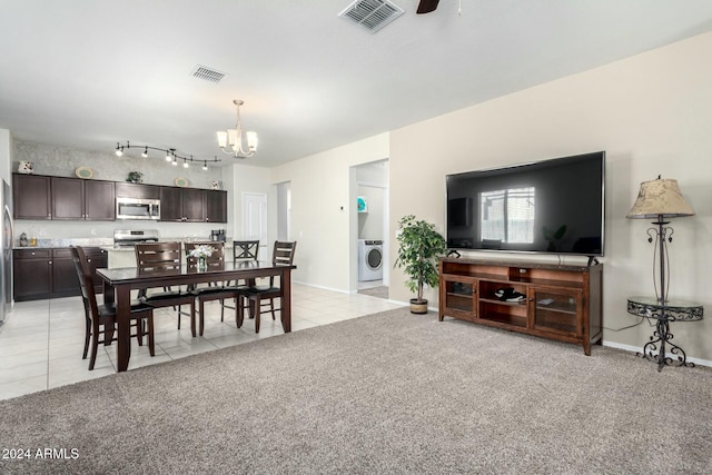 carpeted dining space featuring washer / clothes dryer and ceiling fan with notable chandelier