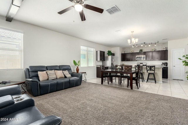 living room with light tile patterned floors and ceiling fan with notable chandelier