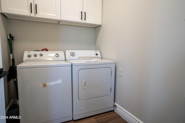 clothes washing area featuring cabinets, independent washer and dryer, and dark hardwood / wood-style flooring