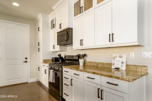 kitchen featuring white cabinets, light stone counters, and stainless steel gas range oven