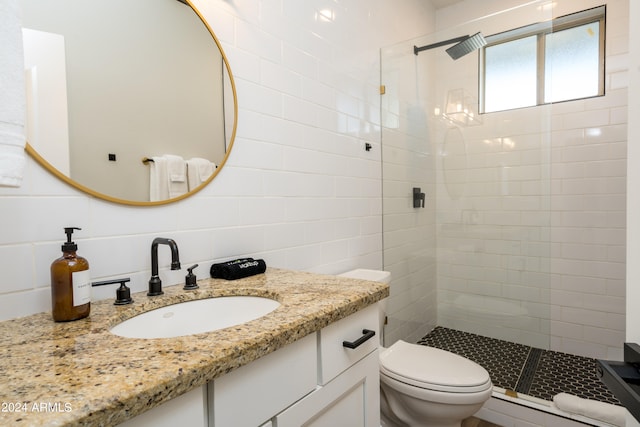 bathroom with toilet, a baseboard heating unit, vanity, and tiled shower