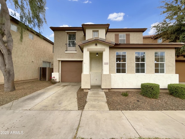 view of front of property featuring a garage, concrete driveway, and stucco siding