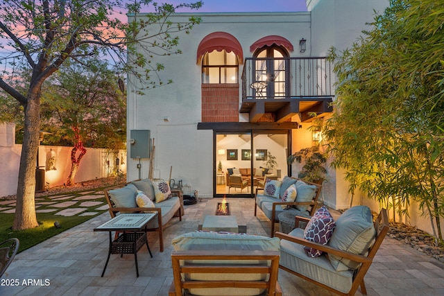 8001 N 3rd Pl, Phoenix, AZ 85020 - back of property at dusk with an outdoor living space with a fire pit, a balcony, a patio area, and stucco siding