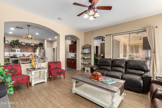 living room featuring ceiling fan and light hardwood / wood-style flooring