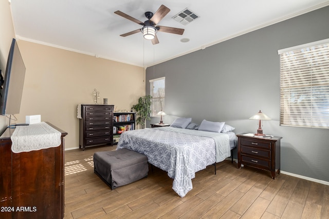 bedroom with wood-type flooring, ceiling fan, and crown molding