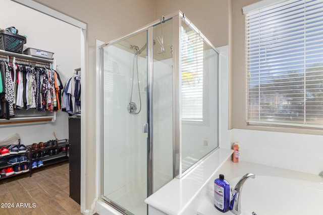 bathroom featuring plus walk in shower, a wealth of natural light, and hardwood / wood-style flooring