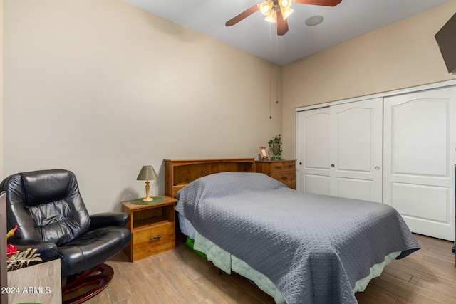 bedroom with light hardwood / wood-style floors, ceiling fan, and a closet