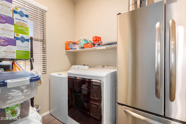 laundry area with washer and clothes dryer and light tile patterned floors