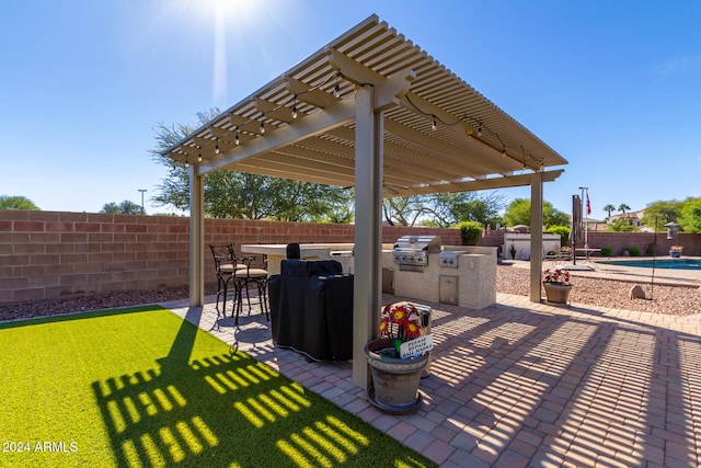 view of patio featuring a pergola, a fenced in pool, an outdoor bar, an outdoor kitchen, and area for grilling