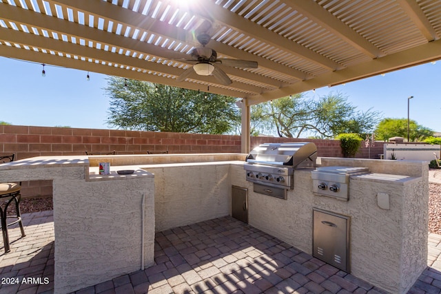 view of patio / terrace with an outdoor kitchen, ceiling fan, a pergola, and grilling area