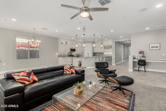 living room with ceiling fan with notable chandelier