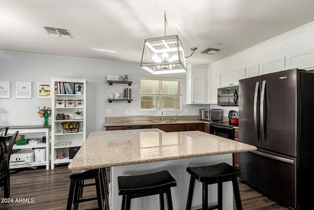 kitchen featuring white cabinets, dark hardwood / wood-style flooring, stainless steel fridge, and a center island