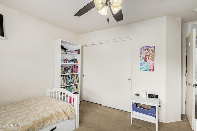 carpeted bedroom featuring ceiling fan and a closet