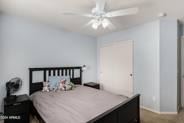 carpeted bedroom featuring ceiling fan and a closet