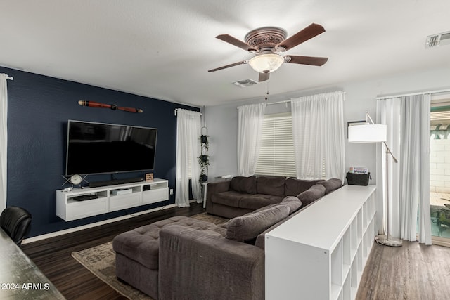 living room featuring ceiling fan and dark wood-type flooring