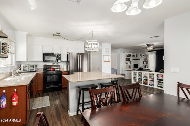 kitchen featuring dark hardwood / wood-style floors, stainless steel refrigerator, light stone counters, and electric stove