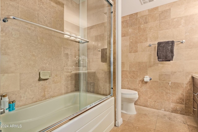 full bathroom featuring shower / bath combination with glass door, vanity, toilet, and tile patterned flooring