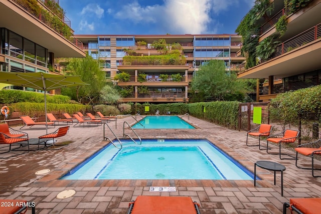 view of swimming pool with a patio and a hot tub