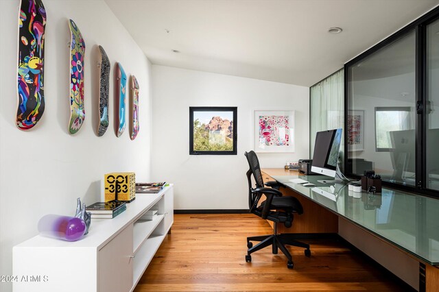 office area featuring light hardwood / wood-style floors and vaulted ceiling