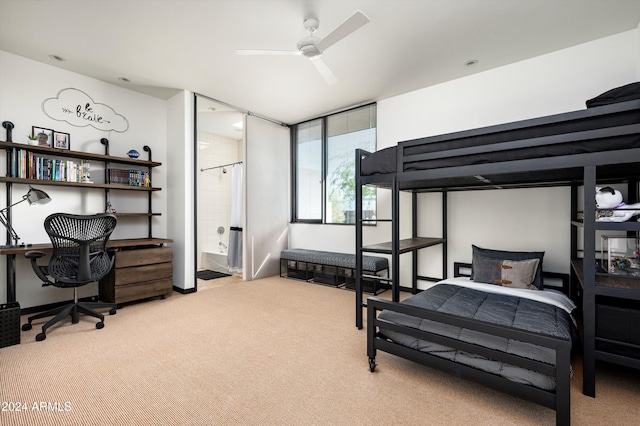 carpeted bedroom with ensuite bathroom and ceiling fan