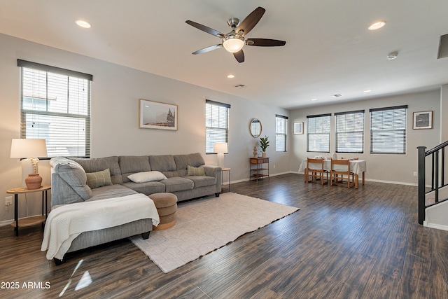 living room featuring dark wood-type flooring, stairway, recessed lighting, and a healthy amount of sunlight