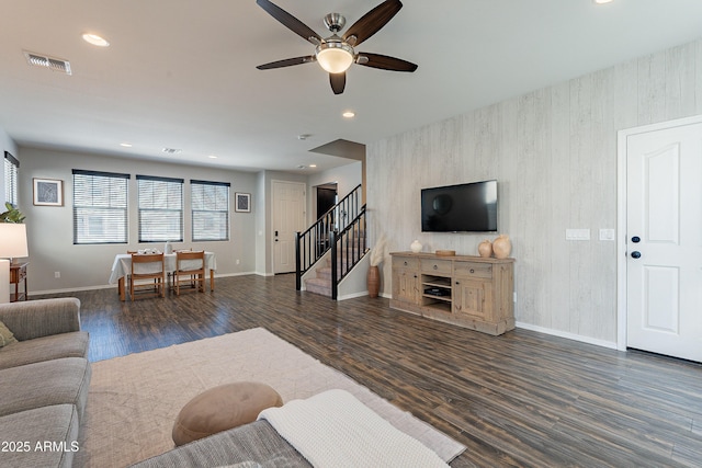 living area featuring baseboards, visible vents, wood finished floors, stairs, and recessed lighting