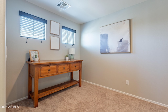 interior space featuring baseboards, visible vents, and light colored carpet