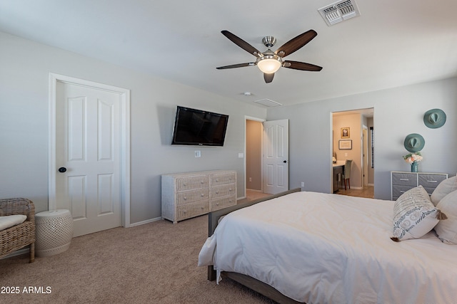 carpeted bedroom with connected bathroom, visible vents, and ceiling fan