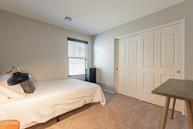 bedroom with light carpet, visible vents, and a closet