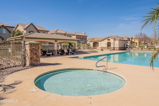 community pool featuring a residential view, a patio area, fence, and a gazebo