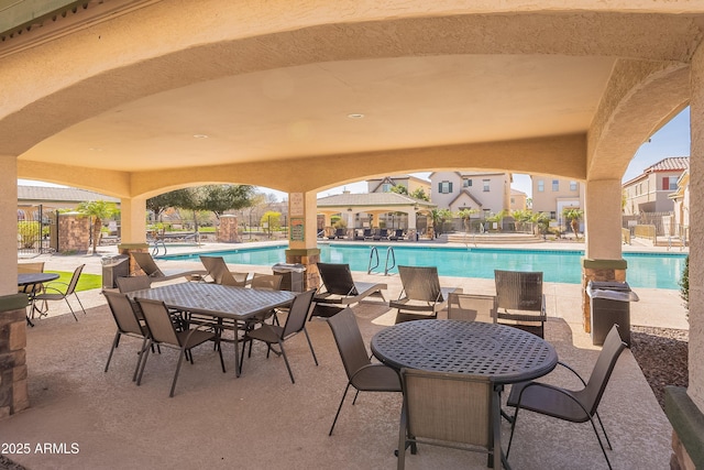 view of patio with fence and a community pool