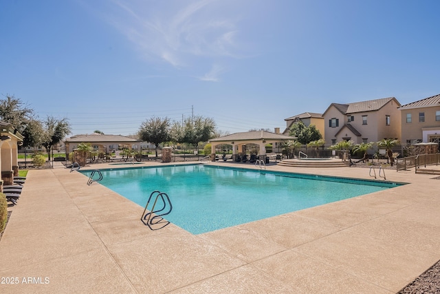 community pool with a gazebo, a patio, and fence