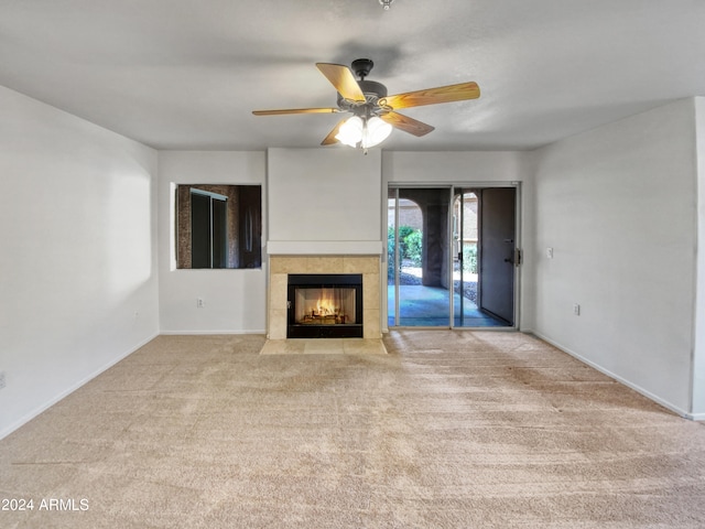 unfurnished living room featuring ceiling fan, a fireplace, and light carpet