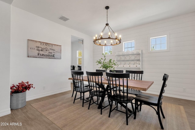 dining room featuring light wood-type flooring and a notable chandelier