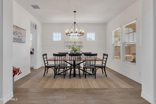 dining area with hardwood / wood-style flooring and a notable chandelier